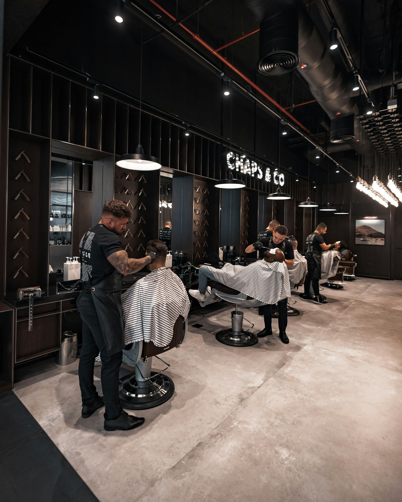 Barbeiros trabalhando na barbearia